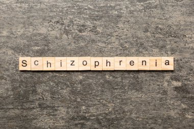 Tahta blokta yazan şizofreni kelimesi. Masada şizofreni metni, konsept.