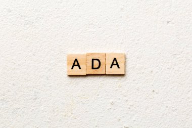 ADA word written on wood block. ADA text on table, concept.