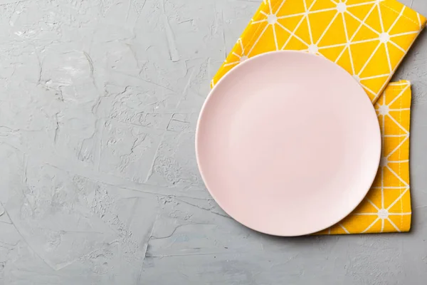 食べ物のためのテーブルクロス上の色の背景の空のラウンドピンクのプレートの上のビュー あなたのデザインのためのスペースとナプキンに空の料理 — ストック写真