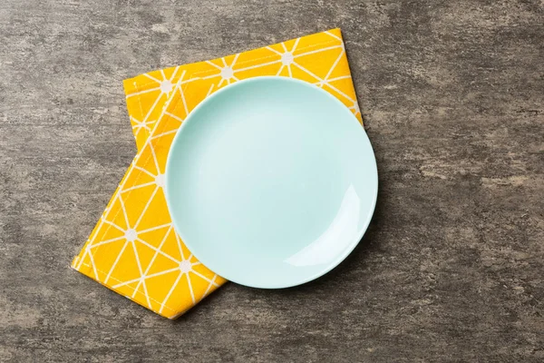 食べ物のためのテーブルクロスの色の背景空のラウンドブループレートの上のビュー あなたのデザインのためのスペースとナプキンに空の料理 — ストック写真