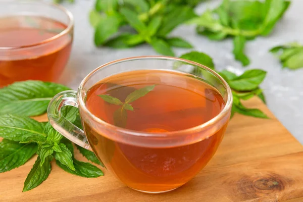 stock image Cup of mint tea on table background. Green tea with fresh mint top view with copy space.