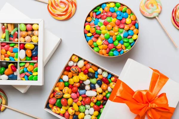 Zestaw Różnych Słodkich Cukierków Papierowym Pudełku Satynową Wstążką Kolorowym Tle — Zdjęcie stockowe
