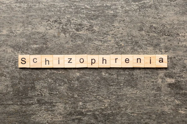 Tahta blokta yazan şizofreni kelimesi. Masada şizofreni metni, konsept.
