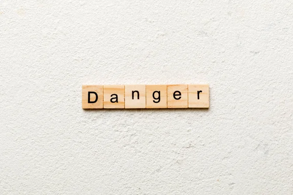 木のブロックに書かれた危険言葉 デザインのセメントテーブルの危険テキスト トップビューコンセプト — ストック写真
