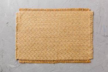 Çimento arka planında yiyecek için kahverengi masa örtüsünün üst görüntüsü. Tasarımın için boş boşluk.