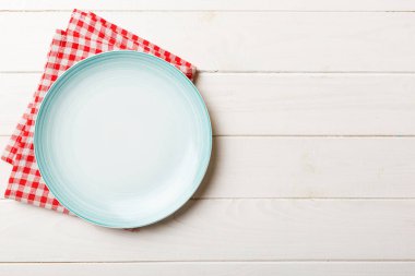 Renkli arkaplanda üst görünüm yiyecek için mavi tabak üzerinde boş. Tasarımınız için boşluk olan peçeteye boş tabak.