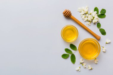 Akasya çiçekli ve yapraklı bal kavanozu. Taze bal üst görünüm düz yatıyordu.