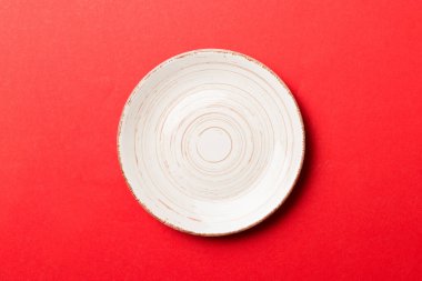 Renkli arka plan görüntüsünün üst görüntüsü yiyecek için boş, yuvarlak bej bir tabak. Tasarımınız için alanı olan boş tabak.