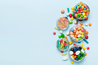 farklı renkte yuvarlak şekerler ve kavanozlar. Fotokopi alanı olan büyük çeşitlilikteki şeker ve şekerlerin üst görünümü.