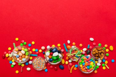 farklı renkte yuvarlak şekerler ve kavanozlar. Fotokopi alanı olan büyük çeşitlilikteki şeker ve şekerlerin üst görünümü.