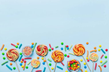 Lezzetli İştah açıcı Parti Aksesuarları Mutlu Yıllar Tatlı. Renkli arkaplanda farklı tipte şekerler, kopyalama alanı. Renkli doğum günü partisi geçmişi.