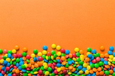 Renkli arka planda karışık renkli şeker koleksiyonu. Düz yerde, üst tarafta. Renkli çikolata kaplı şeker çerçevesi.