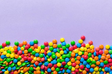 Renkli arka planda karışık renkli şeker koleksiyonu. Düz yerde, üst tarafta. Renkli çikolata kaplı şeker çerçevesi.