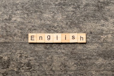 Tahta bloğa yazılmış İngilizce kelime. Deksing, konsept için çimento üzerinde İngilizce metin.