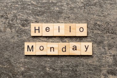 Merhaba pazartesi günü tahta bloğa yazılmış kelime. Merhaba pazartesi metni çimento masasında desing, konsept için.