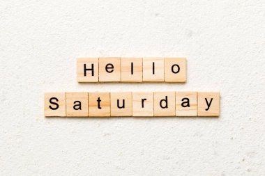 Merhaba cumartesi günü ahşap blokta yazan kelime. Merhaba cumartesi metni çimento masasında desing, konsept için.