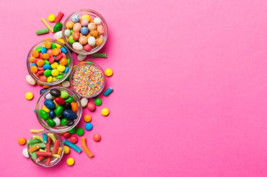 farklı renkte yuvarlak şekerler ve kavanozlar. Fotokopi alanı olan büyük çeşitlilikteki şeker ve şekerlerin üst görünümü.