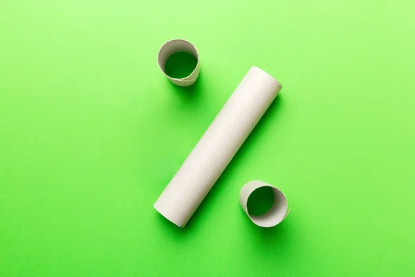 Empty toilet paper roll on colored background. Recyclable paper tube with metal plug end made of kraft paper or cardboard.