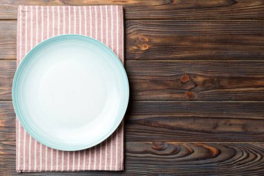 Renkli arkaplanda üst görünüm yiyecek için mavi tabak üzerinde boş. Tasarımınız için boşluk olan peçeteye boş tabak.