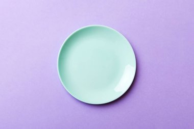Renkli arka planın üst görüntüsü yiyecek için boş mavi tabak. Tasarımınız için alanı olan boş tabak.