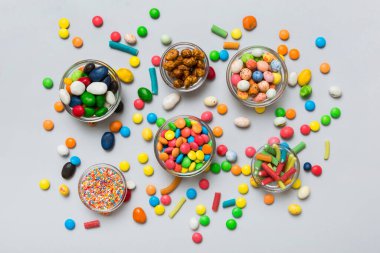 farklı renkte yuvarlak şekerler ve kavanozlar. Fotokopi alanı olan büyük çeşitlilikteki şeker ve şekerlerin üst görünümü.