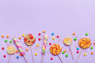 Lezzetli İştah açıcı Parti Aksesuarları Mutlu Yıllar Tatlı. Renkli arkaplanda farklı tipte şekerler, kopyalama alanı. Renkli doğum günü partisi geçmişi.