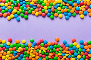 Renkli arka planda karışık renkli şeker koleksiyonu. Düz yerde, üst tarafta. Renkli çikolata kaplı şeker çerçevesi.