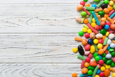 Renkli arka planda karışık renkli şeker koleksiyonu. Düz yerde, üst tarafta. Renkli çikolata kaplı şeker çerçevesi.