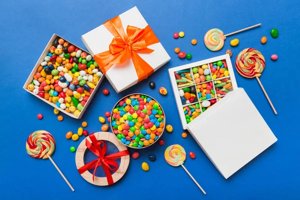 Zestaw Różnych Słodkich Cukierków Papierowym Pudełku Satynową Wstążką Kolorowym Tle — Zdjęcie stockowe