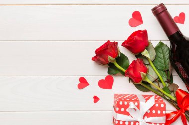Kırmızı şarap, gül çiçeği ve hediye kutusuyla Sevgililer Günü kompozisyonu. Üst manzara, düz yatış. Tatil kavramı.