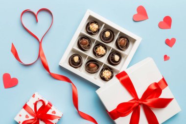 Sevgililer Günü için kutuda lezzetli çikolatalı pralinler. Kalp, hediye kutusuyla şekillendirilmiş çikolatalar fotokopi alanı ile üst görünüm.