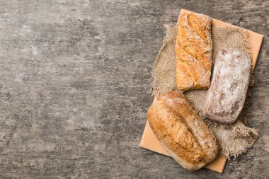 Tahtanın üzerinde beyaz ahşap zemine karşı taze pişmiş ekmek. Kopya alanı olan üst görünüm ekmeği.