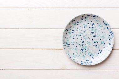 Ahşap zemindeki boş mavi tabağın üst görüntüsü. Tasarımın için boş boşluk.