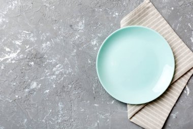 Renkli arkaplanda üst görünüm yiyecek için mavi tabak üzerinde boş. Tasarımınız için boşluk olan peçeteye boş tabak.