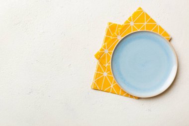 Renkli arkaplanda üst görünüm yiyecek için mavi tabak üzerinde boş. Tasarımınız için boşluk olan peçeteye boş tabak.