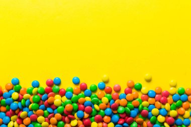 Renkli arka planda karışık renkli şeker koleksiyonu. Düz yerde, üst tarafta. Renkli çikolata kaplı şeker çerçevesi.