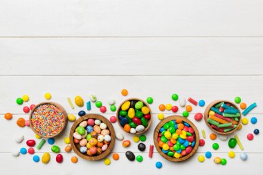 farklı renkte yuvarlak şekerler ve kavanozlar. Fotokopi alanı olan büyük çeşitlilikteki şeker ve şekerlerin üst görünümü.