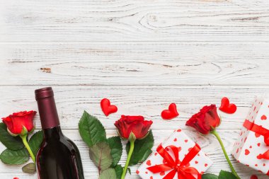 Kırmızı şarap, gül çiçeği ve hediye kutusuyla Sevgililer Günü kompozisyonu. Üst manzara, düz yatış. Tatil kavramı.