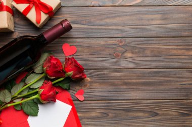 Kırmızı şarap, gül çiçeği ve hediye kutusuyla Sevgililer Günü kompozisyonu. Üst manzara, düz yatış. Tatil kavramı.
