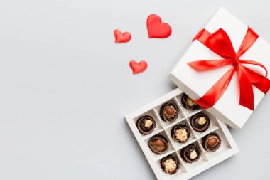 Sevgililer Günü için kırmızı kutuda lezzetli çikolatalı pralinler. Kalp şeklinde çikolata kutusu, fotokopi alanı ile üst görünüm..