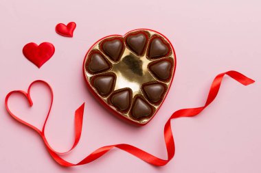 Sevgililer Günü için kırmızı kutuda lezzetli çikolatalı pralinler. Kalp şeklinde çikolata kutusu, fotokopi alanı ile üst görünüm..