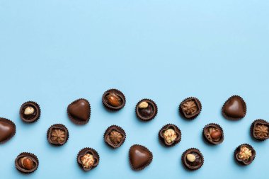 Renkli masa üzerinde farklı çikolata çeşitleri var. Kopya alanı ile Üst Görünüm ve Düz Yatay.