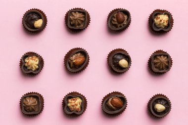 Renkli masa üzerinde farklı çikolata çeşitleri var. Üst Görünüm ve Düz Yatay.