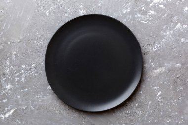 Çimento arka planındaki siyah plakanın üst görüntüsü. Tasarımın için boş boşluk.