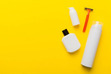 Tıraş Adam seti. Traş makinesi, havlu, losyon ve renkli arka planda tıraş köpüğü. Erkekler banyo aksesuarları üst görünüm.