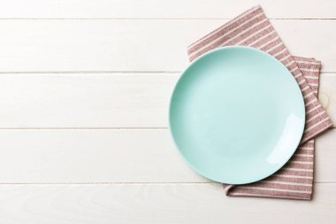 Renkli arkaplanda üst görünüm yiyecek için mavi tabak üzerinde boş. Tasarımınız için boşluk olan peçeteye boş tabak.