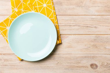 Renkli arkaplanda üst görünüm yiyecek için mavi tabak üzerinde boş. Tasarımınız için boşluk olan peçeteye boş tabak.