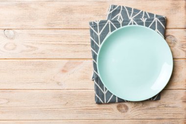 Renkli arkaplanda üst görünüm yiyecek için mavi tabak üzerinde boş. Tasarımınız için boşluk olan peçeteye boş tabak.