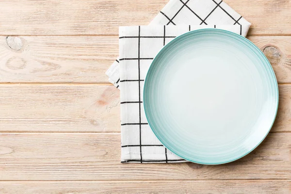 Renkli arkaplanda üst görünüm yiyecek için mavi tabak üzerinde boş. Tasarımınız için boşluk olan peçeteye boş tabak.