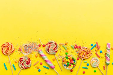 Lezzetli İştah açıcı Parti Aksesuarları Mutlu Yıllar Tatlı. Renkli arkaplanda farklı tipte şekerler, kopyalama alanı. Renkli doğum günü partisi geçmişi.